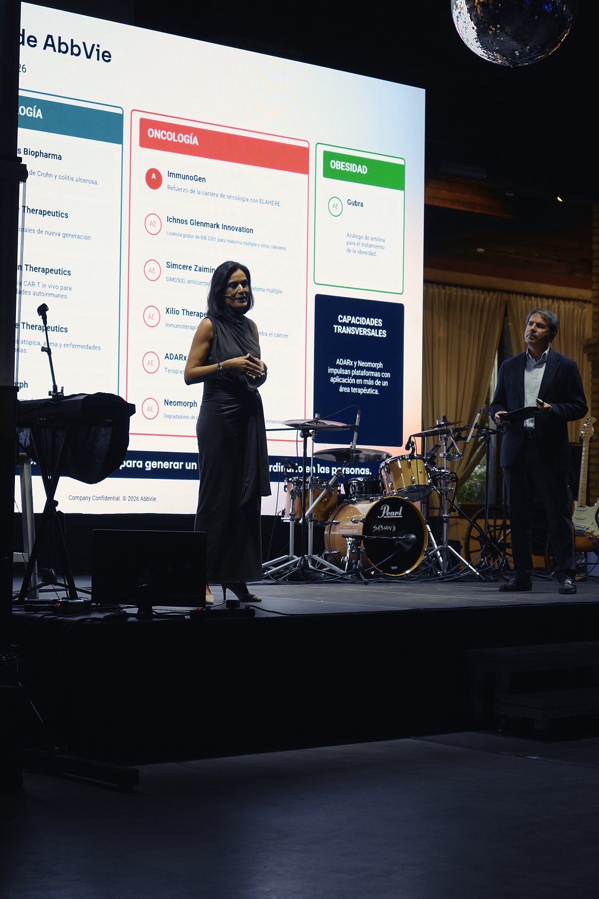 Ponente en el escenario presentando ante la pantalla con sus diapositivas, en la reunión nacional de una compañía farmacéutica