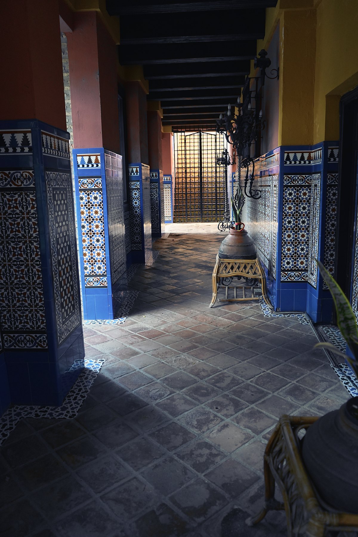 Galería porticada con zócalos de azulejo azul en una hacienda de Sevilla