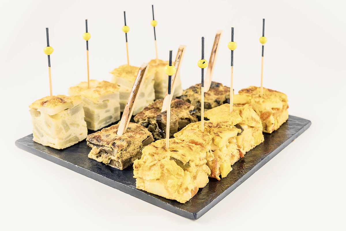 Pinchos de tortilla de patatas con palillos, bocado salado de coffee break