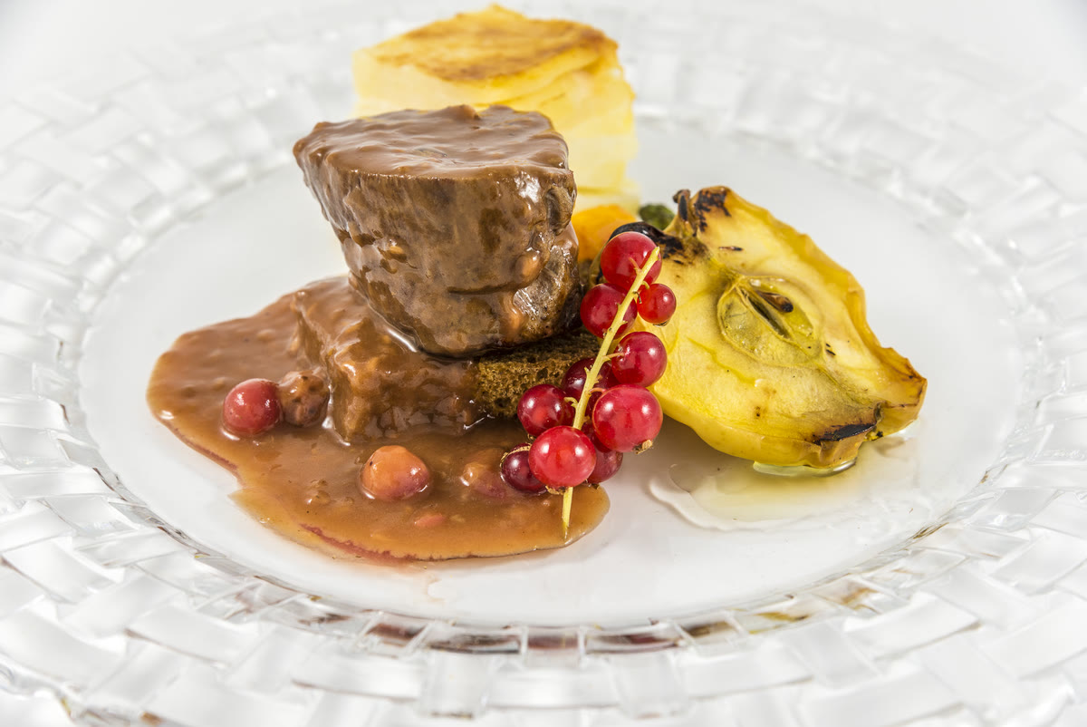 Carrillera glaseada con alcachofa a la brasa y grosellas, cocina de autor para eventos